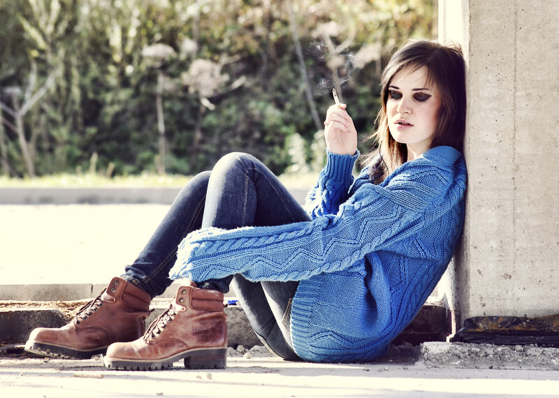 woman smoking by wall