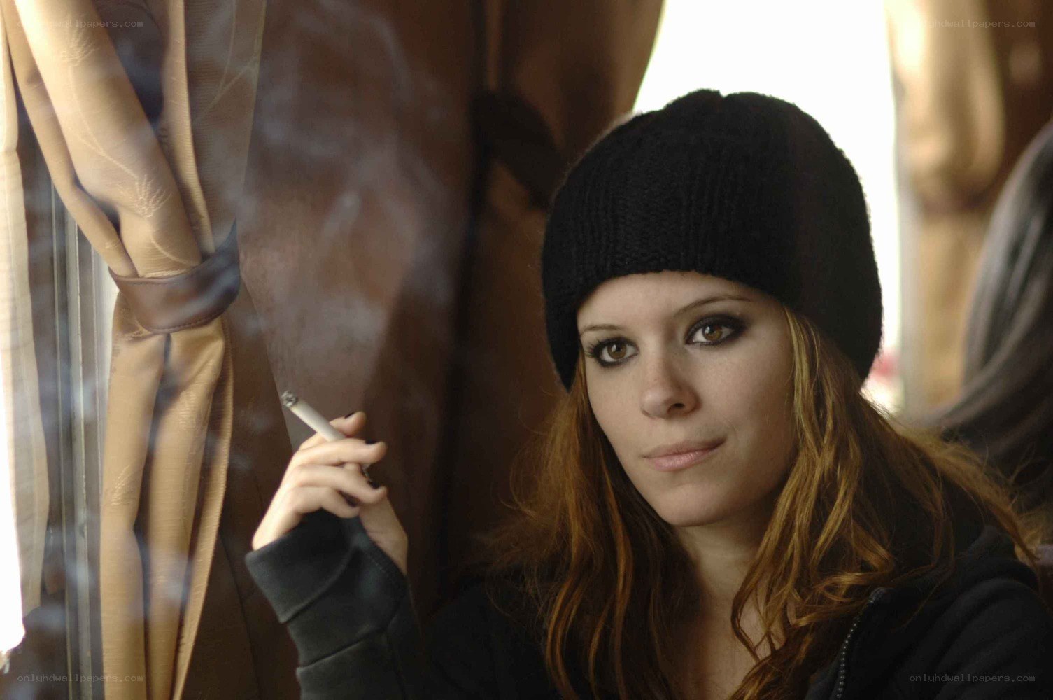 woman smoking by window
