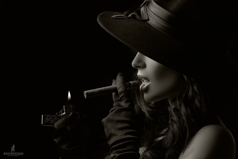 woman smoking cigar in hat