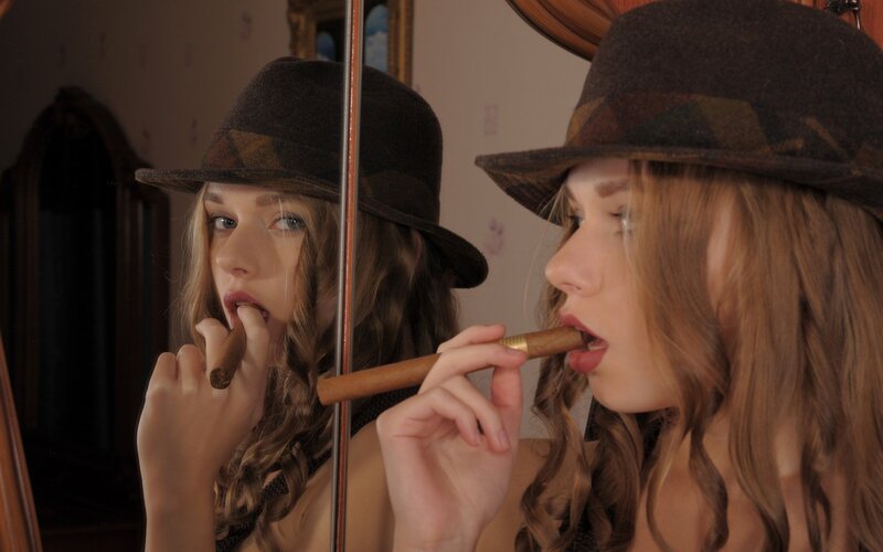 woman smoking cigar in mirror