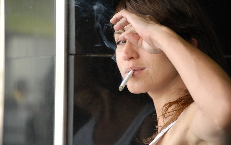 woman smoking near window