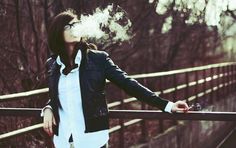 woman smoking on a bridge