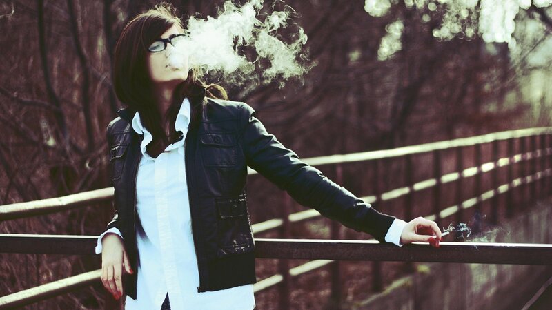 woman smoking on a bridge