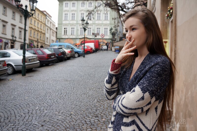 Woman smoking on a cobblestone street