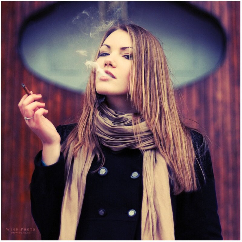 woman smoking under umbrella