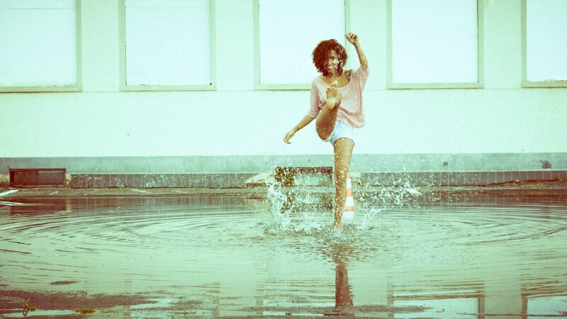 woman splashing in a puddle