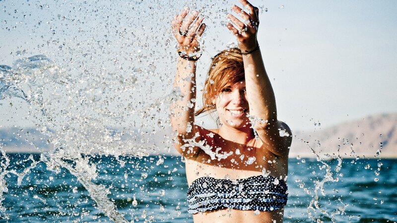 woman splashing water at beach