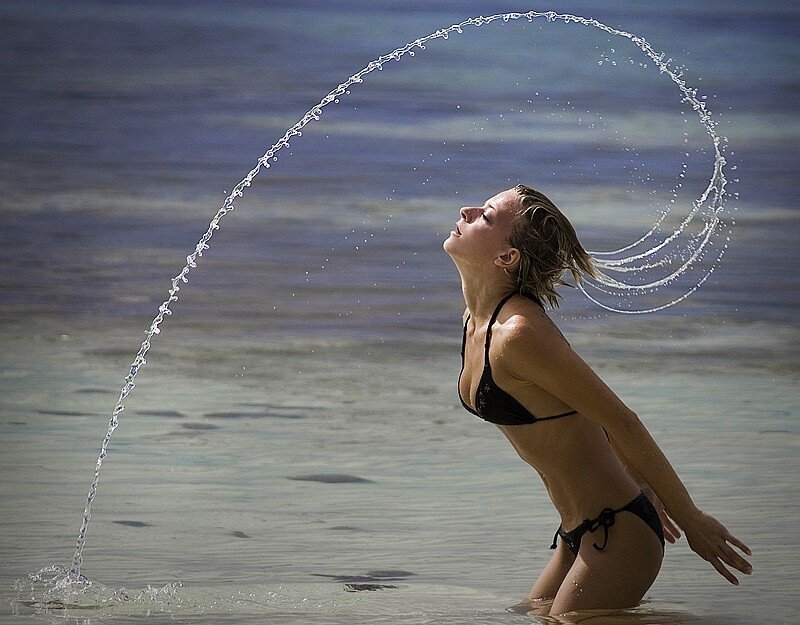 woman splashing water at beach