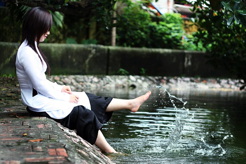 Woman splashing water by a pond