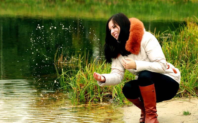 woman splashing water by lake