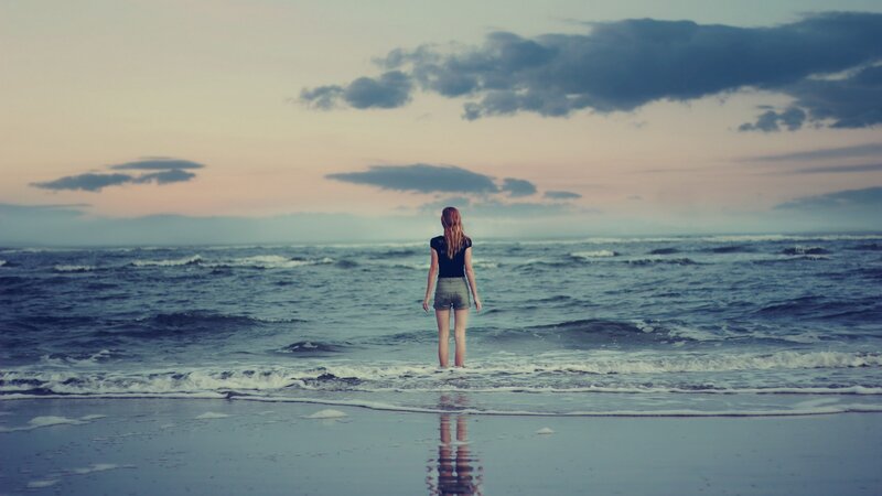 woman standing at the shoreline