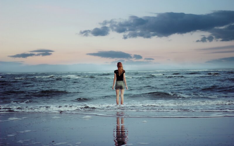 woman standing at the shoreline