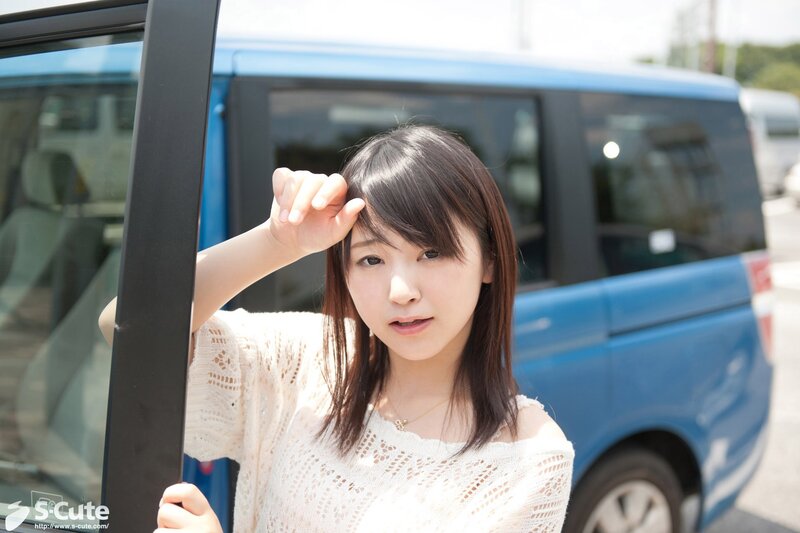 woman standing by a blue car