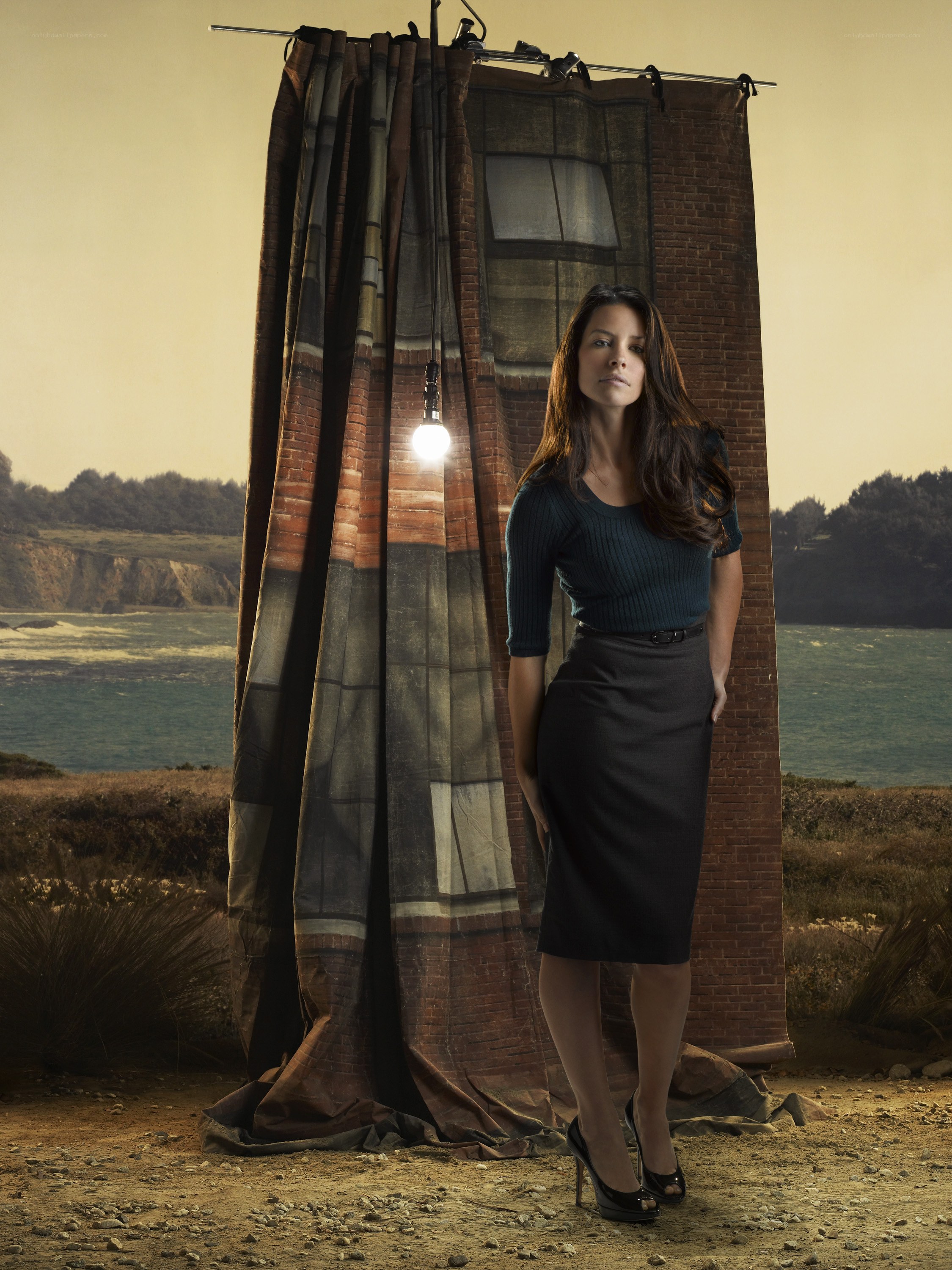 Woman standing by a brick backdrop