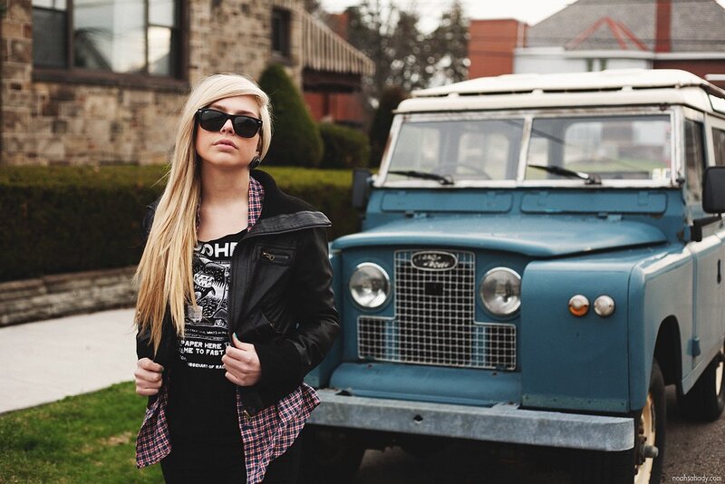woman standing by a vintage jeep