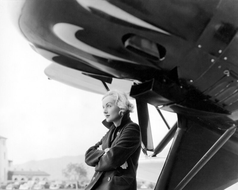 Woman standing by an airplane