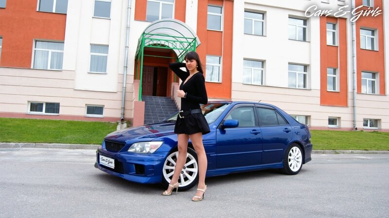 Woman Standing by Car — Blue, Neutral, Afternoon, Photograph, Building, Grass