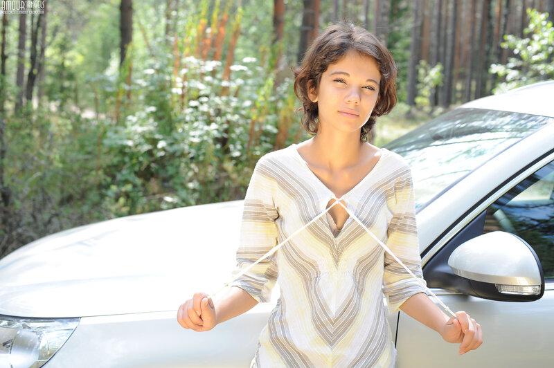woman standing by car in forest
