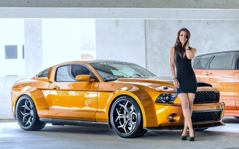 Woman Standing by Car — Orange, Confident