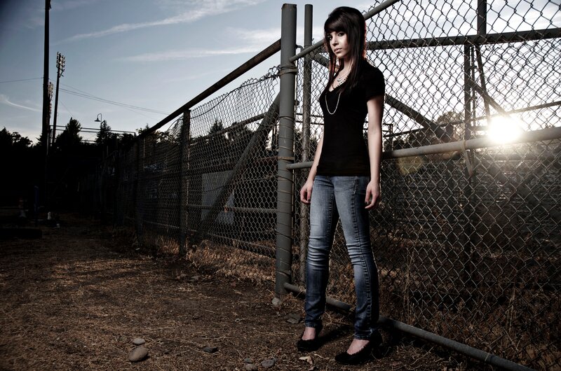 woman standing by chain-link fence