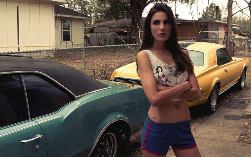 woman standing by classic cars