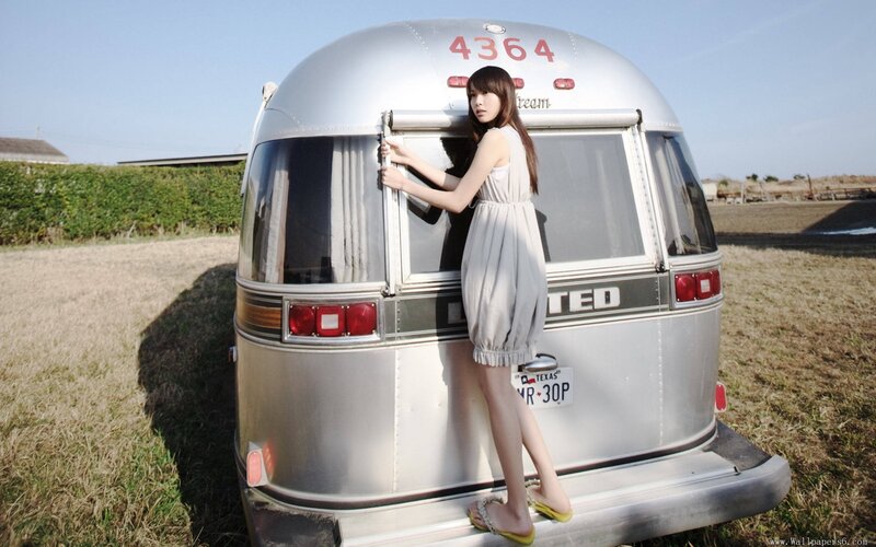 woman standing by vintage trailer