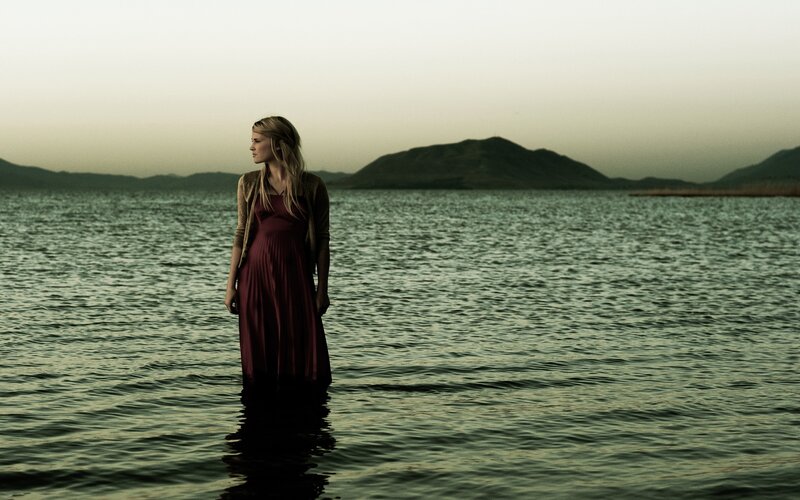 woman standing in water at dusk