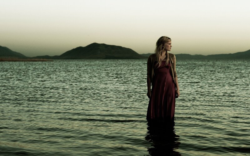 woman standing in water at dusk