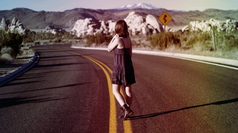 Woman standing on a desert road