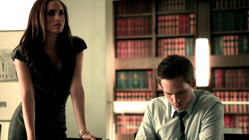 woman standing over man at desk