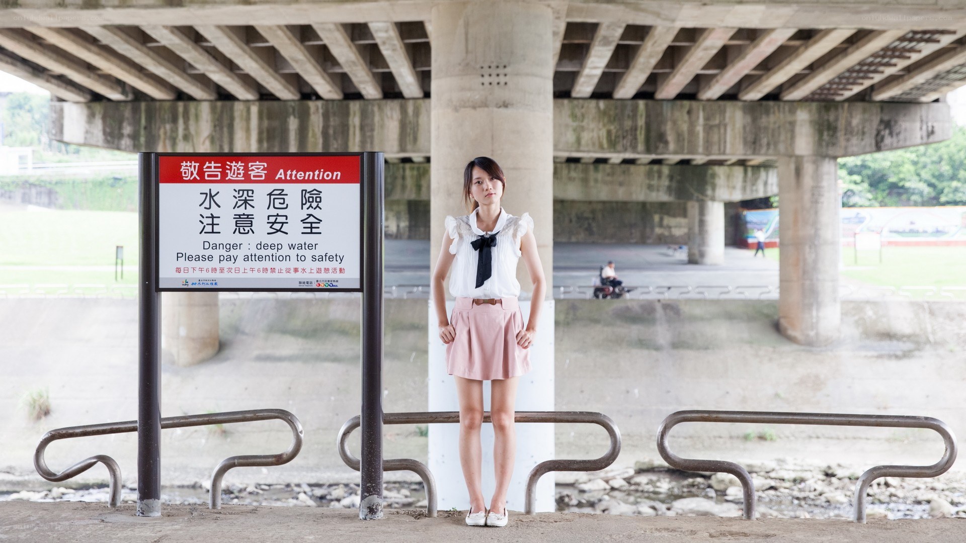 Woman standing under a bridge