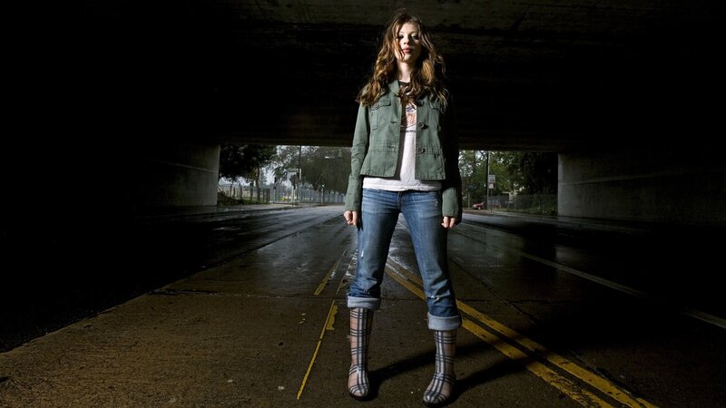 woman standing under a bridge