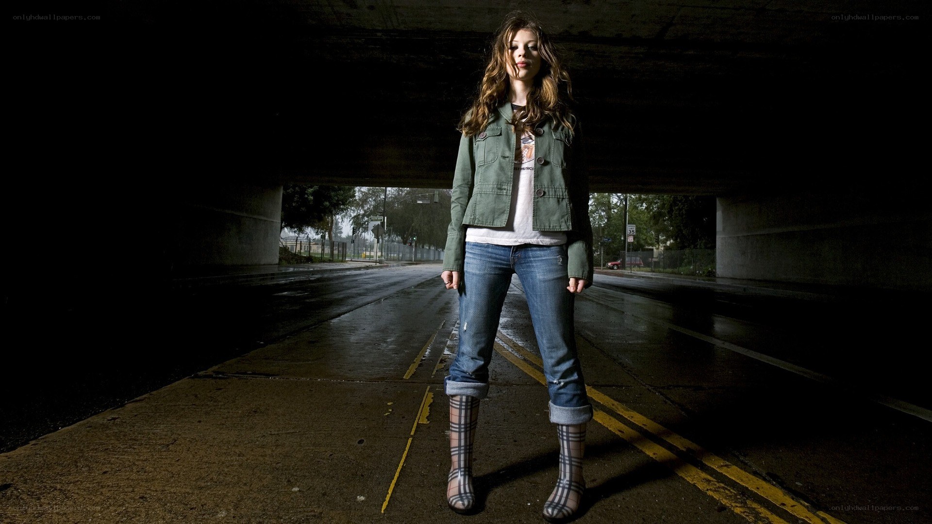 woman standing under a bridge