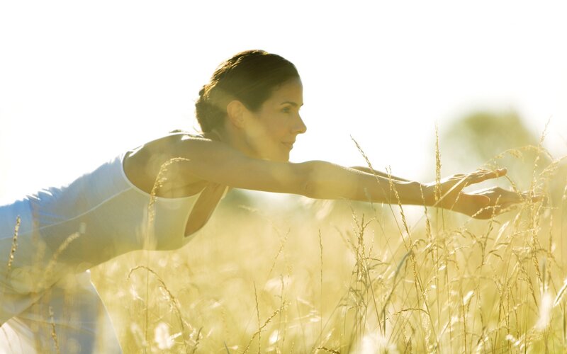 Woman stretching in a field