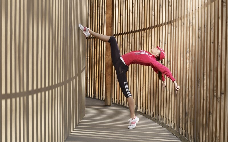 woman stretching in a wooden corridor