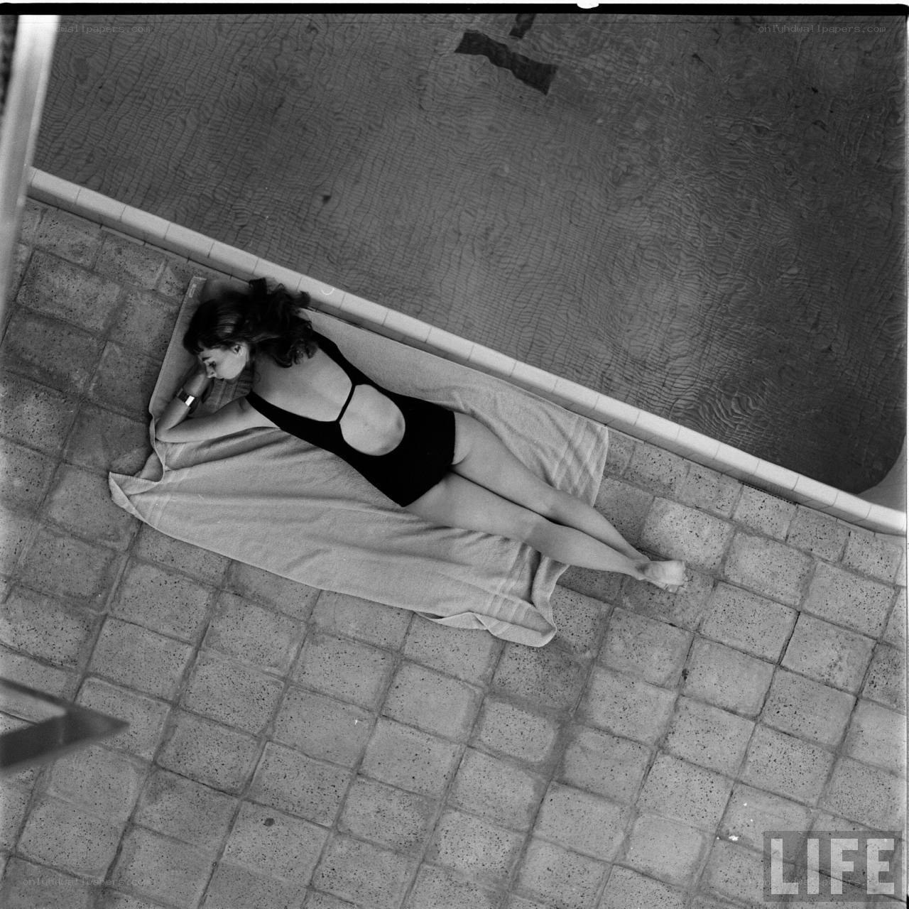 Woman sunbathing by pool
