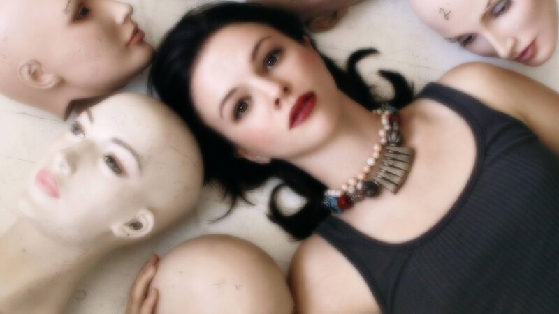 woman surrounded by mannequin heads