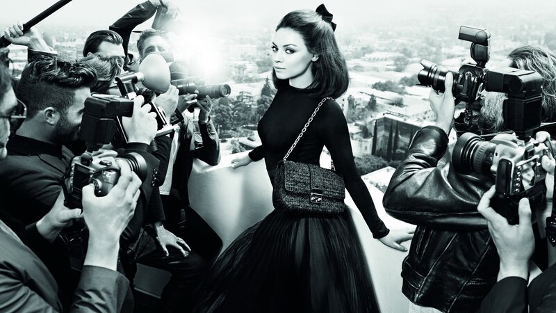 woman surrounded by photographers