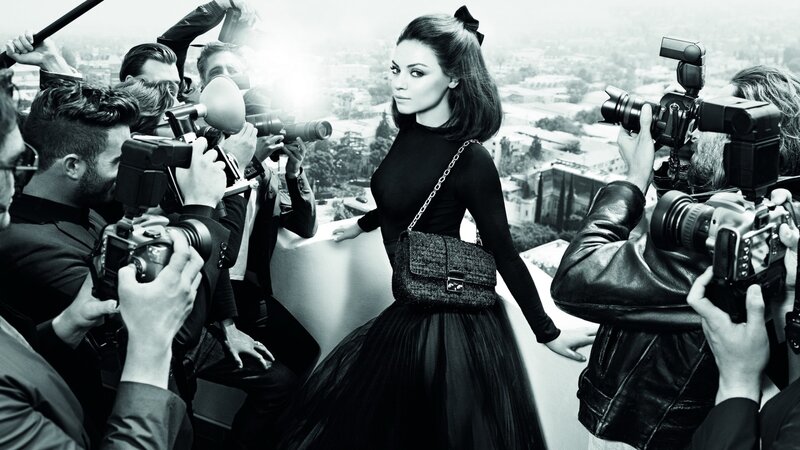 woman surrounded by photographers