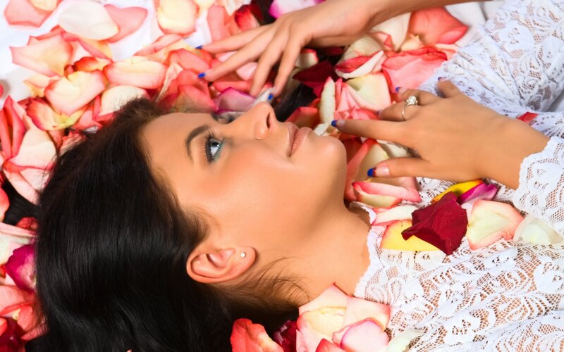 woman surrounded by rose petals