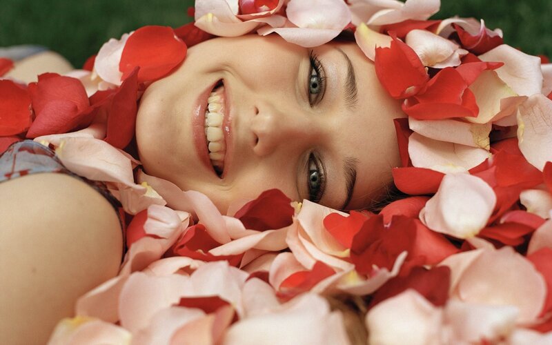 Woman Surrounded by Rose Petals — Red, Joyful