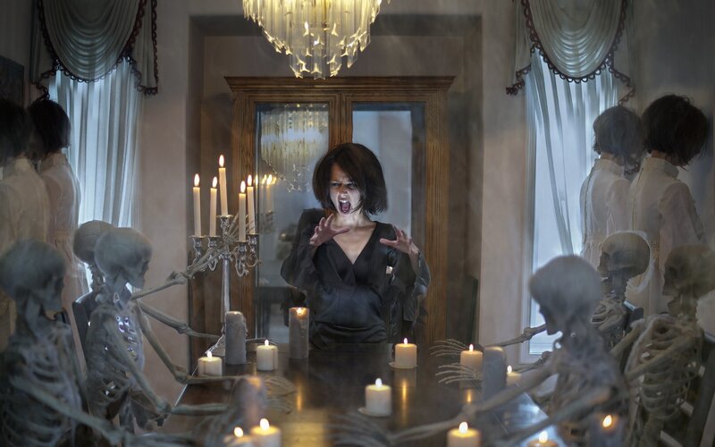 Woman Surrounded by Skeletons