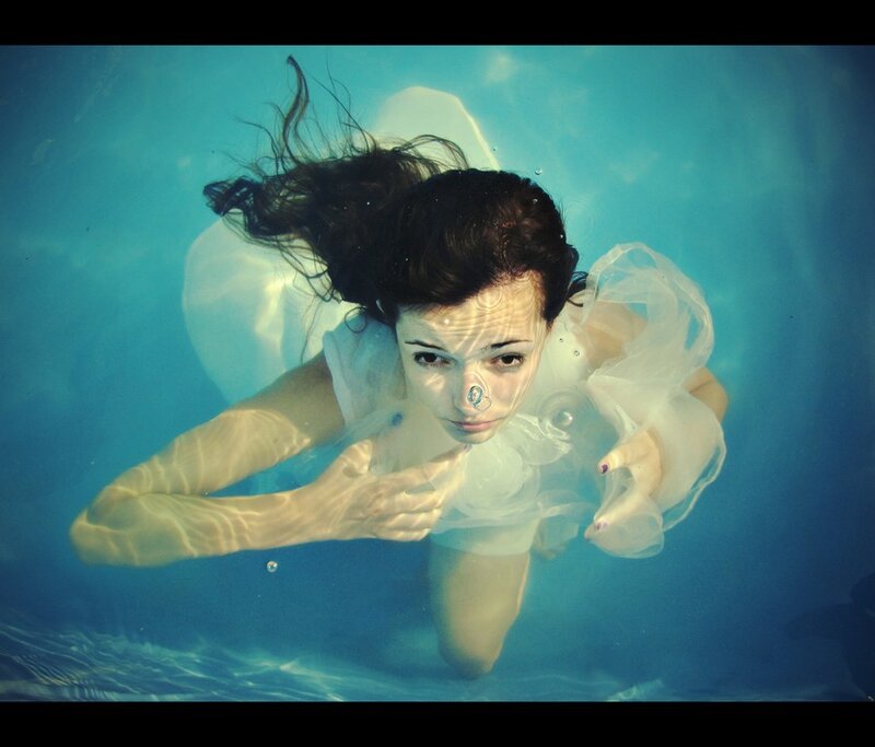 woman swimming underwater in white dress
