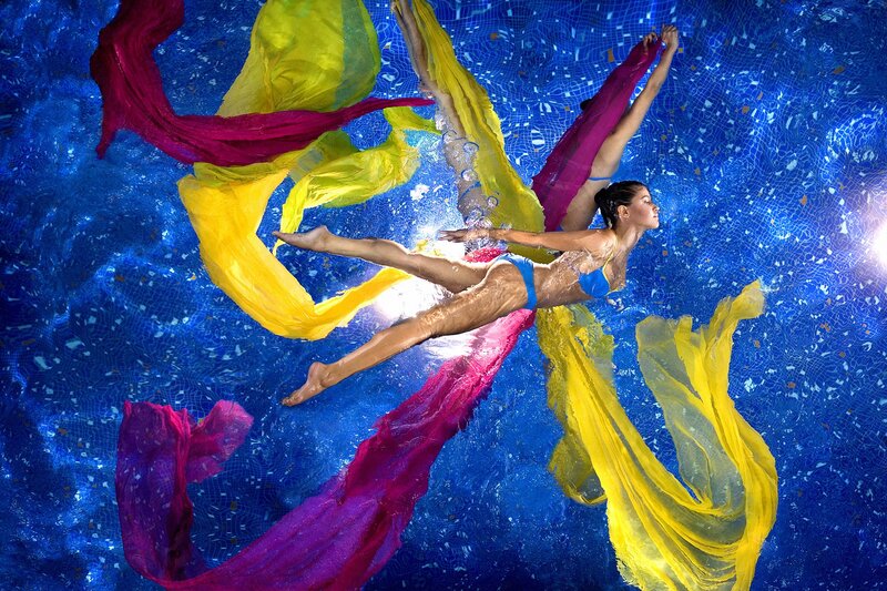 woman swimming underwater with fabric