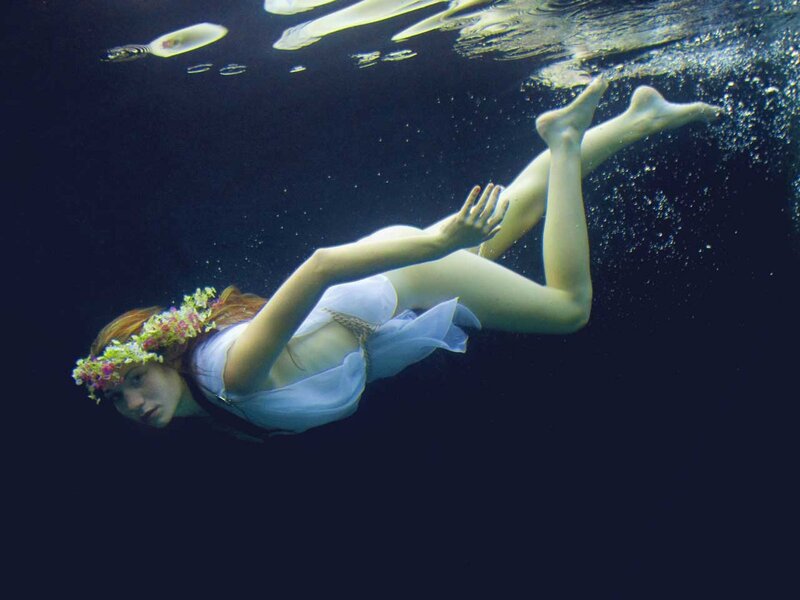 woman swimming underwater with flowers