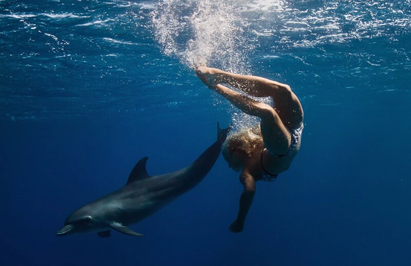 Woman Swimming with Dolphin