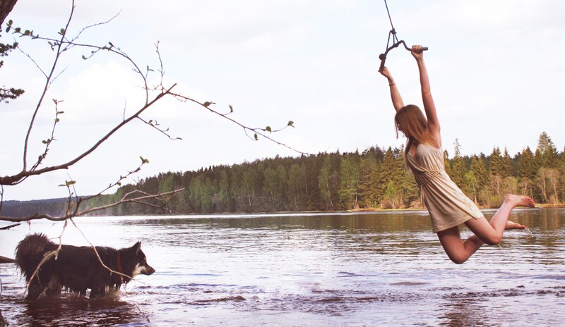 Woman swinging over a lake
