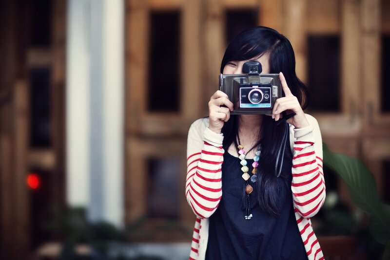 woman taking a photo with vintage camera