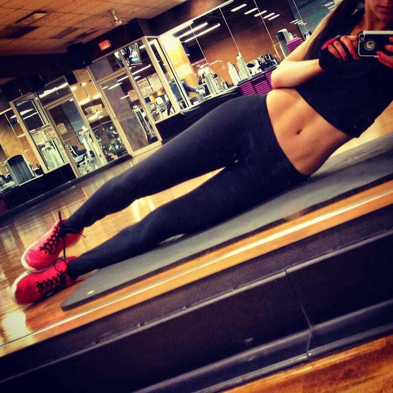 woman taking mirror selfie at gym