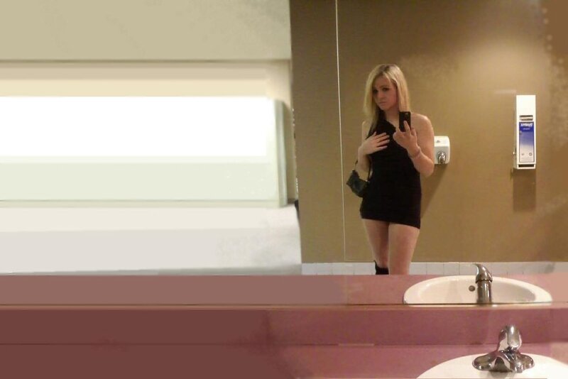 Woman taking mirror selfie in bathroom